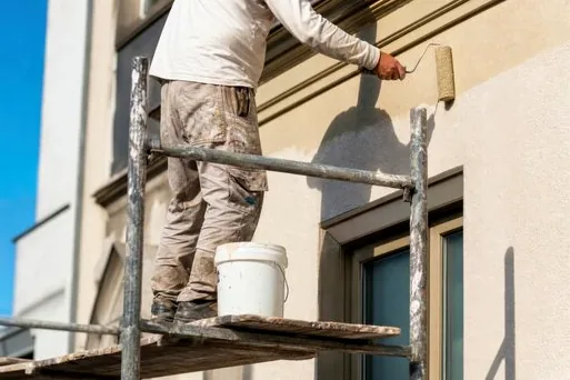 Crew on scaffolding repainting a stucco home in Alta Vista