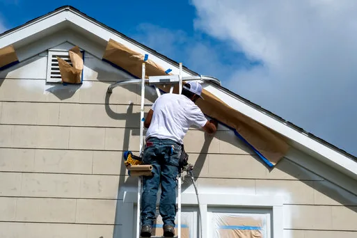 Painter masking windows on a North Redondo townhome before painting